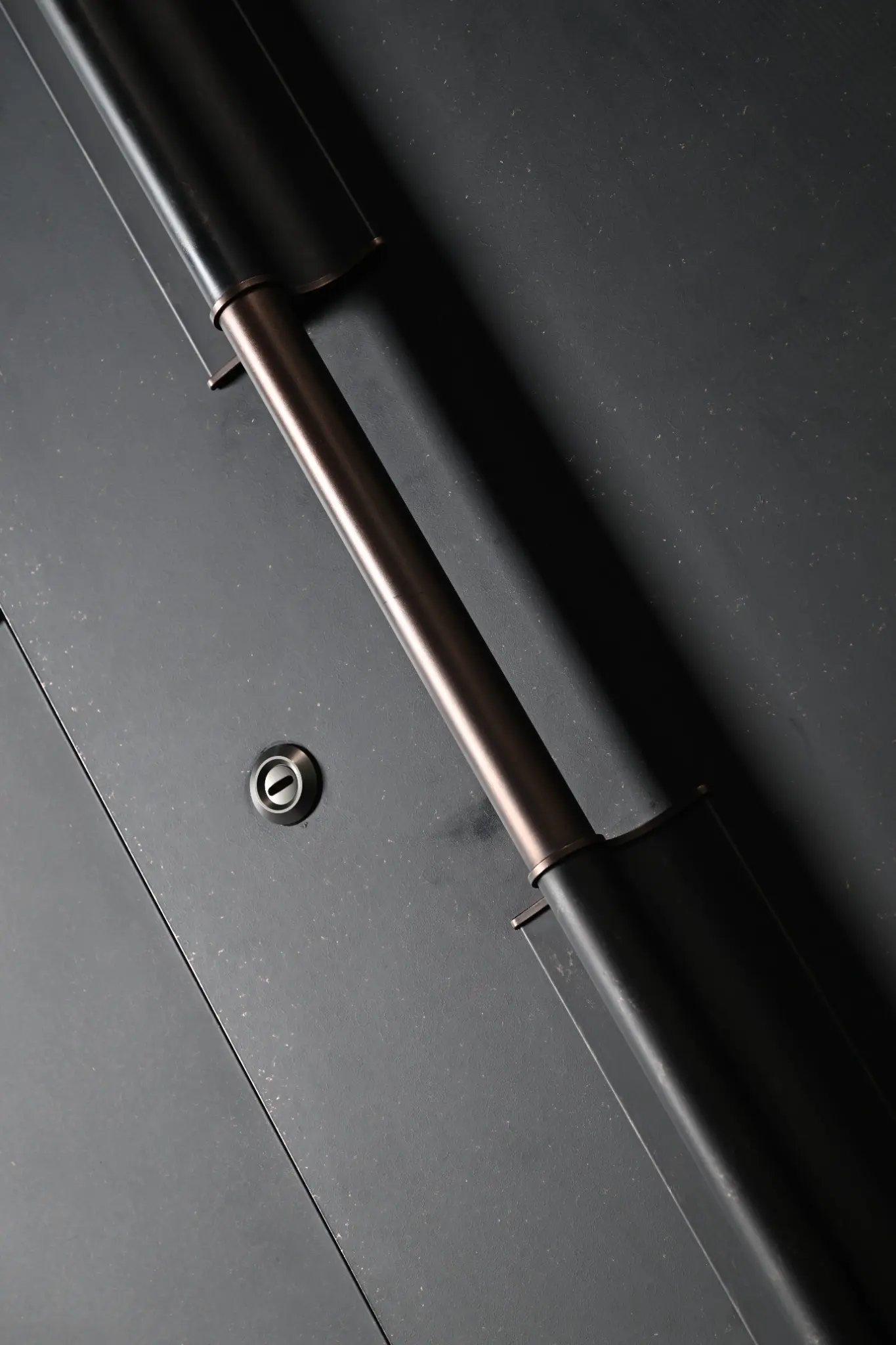 Close-up of a concealed hinge and coordinated dark door finish