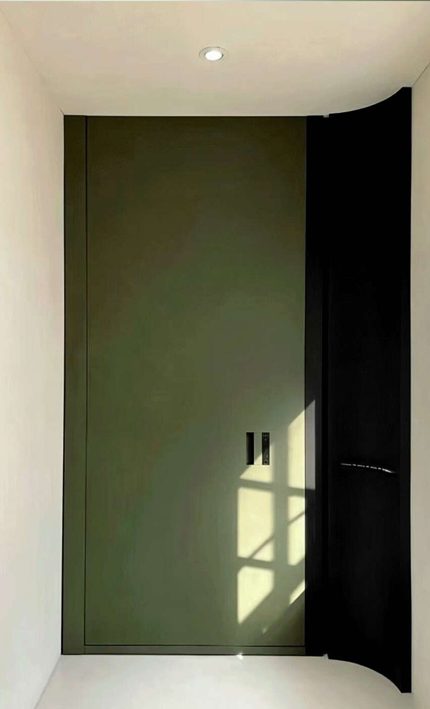 A flush green entrance coordinated with the geometry and light of its interior